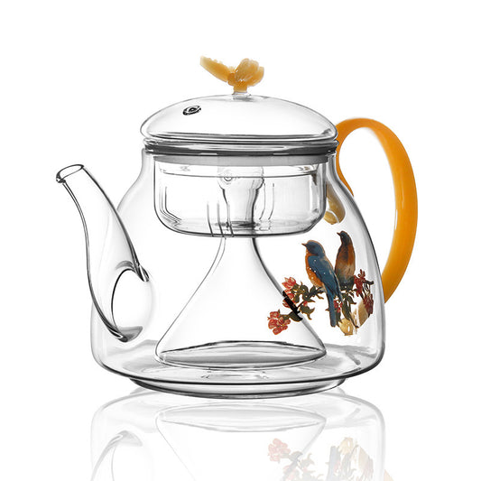Clear borosilicate glass teapot with cartoon flower print on a table

Close-up of drip-friendly spout on flower teapot

Hand holding borosilicate glass teapot with cute floral design

Tea brewing visible through clear flower teapot body
